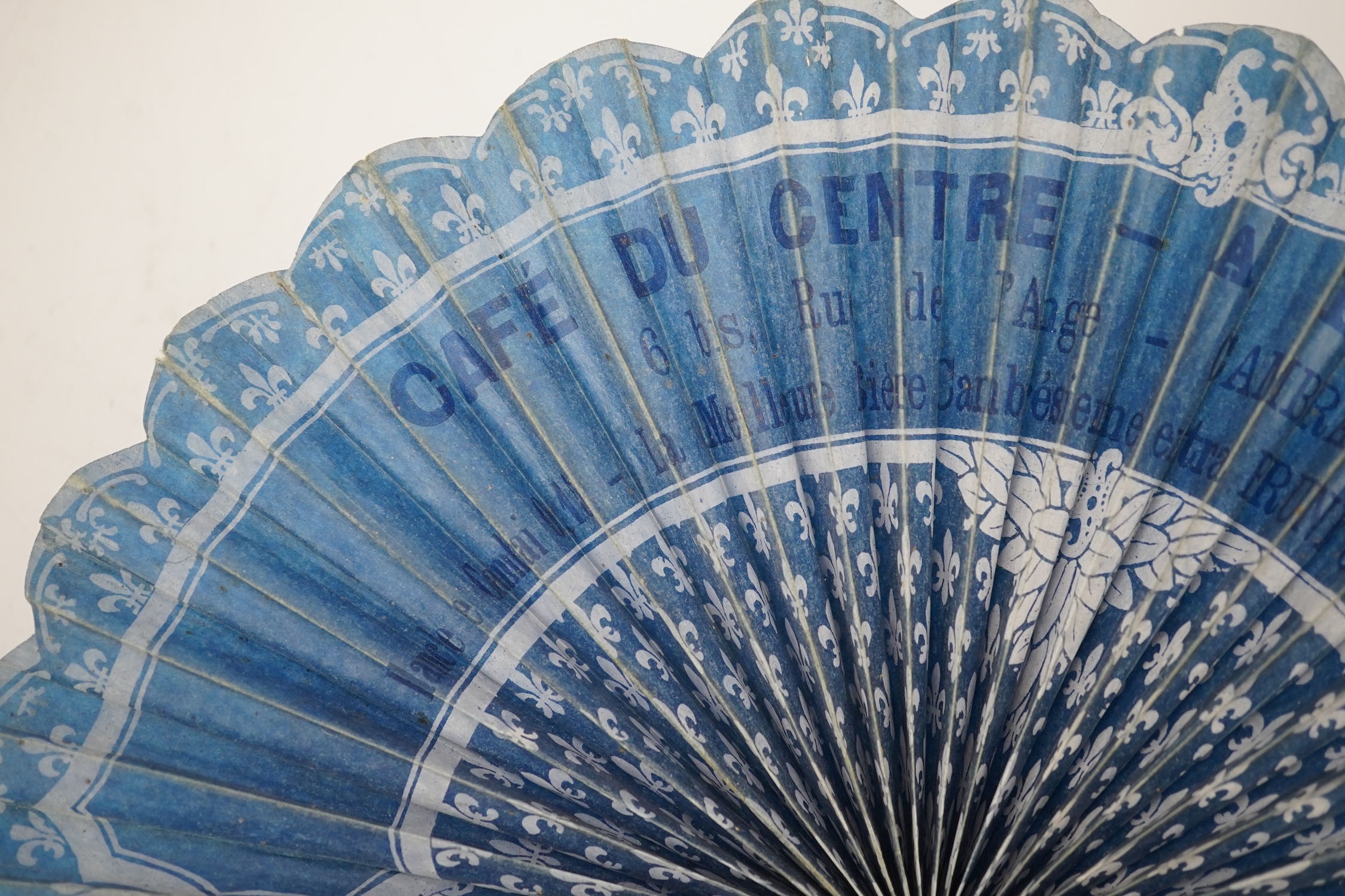 Three novelty fans with a mixed Brussels lace fan and black lace fan, a small language of love in flowers fan, a paper windmill advertising French Café fan, a carved cream Bakelite fan, a black and gilt, lace and sequin